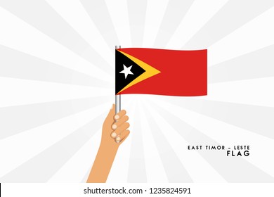 Vector cartoon illustration of human hands hold East Timor flag. Isolated object on white background.