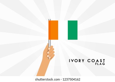 Vector cartoon illustration of human hands hold ivory coast flag. Isolated object on white background.