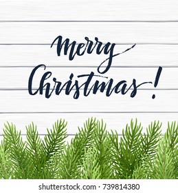 Vector Christmas background with lettering and green fir branches on a white wooden background.