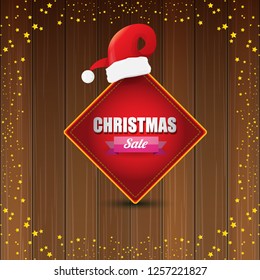 vector Christmas sales banner or tag label with red santa hat on wooden background with stars. Red winter Christmas sale poster design template or background - Vector