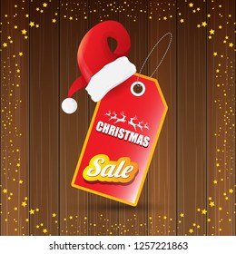 vector Christmas sales banner or tag label with red santa hat on wooden background with stars. Red winter Christmas sale poster design template or background - Vector