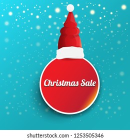 vector Christmas sales paper banner or tag label with red santa hat on snowy azure background with falling snowflakes. Red winter Christmas sale poster design template or background