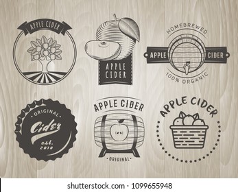 Vector cider labels and logos. Set of retro badges for apple cider drink. Vintage wooden background.