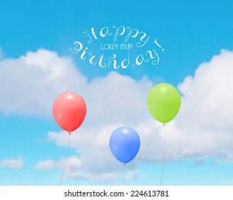 Vector colorful helium balloons over a blue sky with clouds. Birthday greeting card.