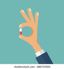 Vector concept flat style illustration of human hand holding the medicine pill between fingers.