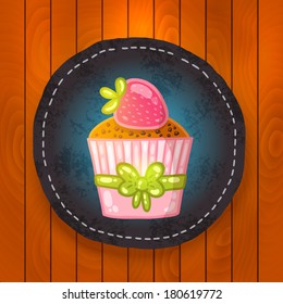 vector cupcake with chocolate and strawberry. Muffin badge on wood background