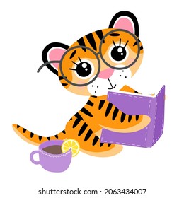 Vector cute little tiger cub, reading a book, in glasses and with cup of tea with a slice of lemon. Autumn hobbies or library concept. Symbol of 2022 New Year, isolated on white background