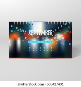 Vector desk spiral calendar. Blurred background with shadows and sparks. September. 