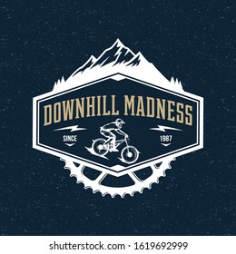 Vector downhill mountain biking badge, logo, label with rider on a bike and mountain silhouette. Downhill, enduro, cross-country biking illustration