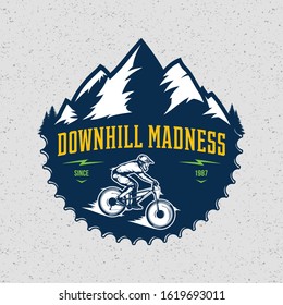 Vector downhill mountain biking badge, logo, label with rider on a bike and mountain silhouette. Downhill, enduro, cross-country biking illustration