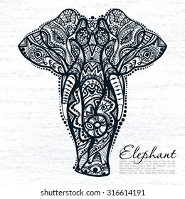 Vector drawing of a elephant with ethnic patterns of India. On the grange background. Image as a tattoo.