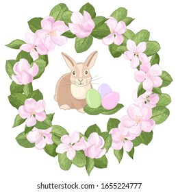 Vector Easter Bunny rabbit with multicolored eggs in a frame wreath of pink apple blossom flowers on a white background