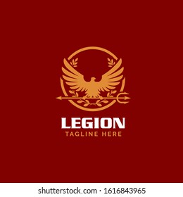 Vector emblem featuring a Roman gold eagle silhouette with spread wings inside a circular laurel wreath. Design includes a horizontal trident spear and bold "LEGION" typography on a dark red background.