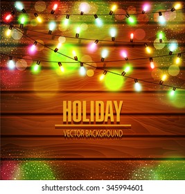 Vector festive background of luminous garlands of light bulbs on a wooden background