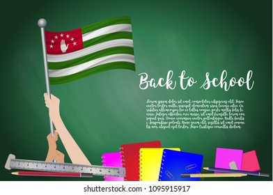 Vector flag of Abkhazia on Black chalkboard background. Education Background with Hands Holding Up of Abkhazia flag. Back to school with pencils, books, school items learning and childhood concept.