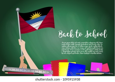 Vector flag of Antigua and Barbuda on Black chalkboard background. Education Background with Hands Holding Up of Antigua and Barbuda flag. Back to school with pencils, books, school items learning.