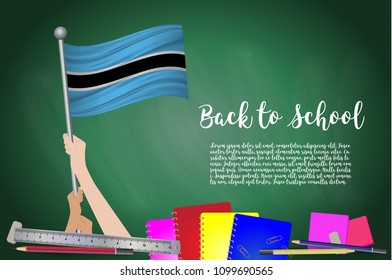 Vector flag of botswana on Black chalkboard background. Education Background with Hands Holding Up of botswana flag. Back to school with pencils, books, school items learning and childhood concept.