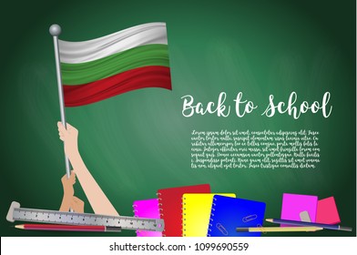 Vector flag of Bulgaria on Black chalkboard background. Education Background with Hands Holding Up of Bulgaria flag. Back to school with pencils, books, school items learning and childhood concept.