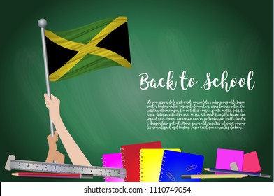 Vector flag of Jamaica on Black chalkboard background. Education Background with Hands Holding Up of Jamaica flag. Back to school with pencils, books, school items learning and childhood concept.
