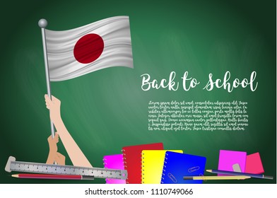 Vector flag of Japan on Black chalkboard background. Education Background with Hands Holding Up of Japan flag. Back to school with pencils, books, school items learning and childhood concept.