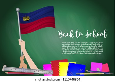 Vector flag of Liechtenstein on Black chalkboard background. Education Background with Hands Holding Up of Liechtenstein flag. Back to school with pencils, books, school items learning and childhood