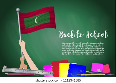 Vector flag of Maldives on Black chalkboard background. Education Background with Hands Holding Up of Maldives flag. Back to school with pencils, books, school items learning and childhood concept
