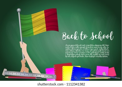 Vector flag of Mali on Black chalkboard background. Education Background with Hands Holding Up of Mali flag. Back to school with pencils, books, school items learning and childhood concept.