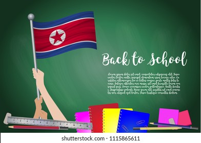 Vector flag of North Korea on Black chalkboard background. Education Background with Hands Holding Up of North Korea flag. Back to school with pencils, books, school items learning and childhood