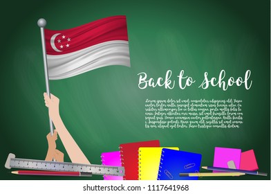 Vector flag of Singapore on Black chalkboard background. Education Background with Hands Holding Up of Singapore flag. Back to school with pencils, books, school items learning and childhood concept.