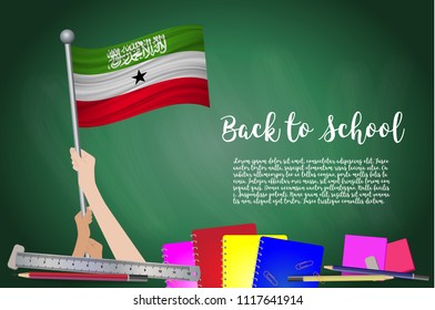 Vector flag of Somaliland on Black chalkboard background. Education Background with Hands Holding Up of Somaliland flag. Back to school with pencils, books, school items learning and childhood