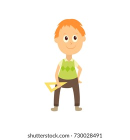 vector flat cartoon male character - cute boy pupil, schoolkid standing smiling holding triangle in hands. Isolated illustration on a white background.