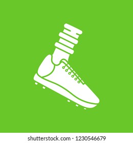 Vector flat icon of soccer footbal boot and sock. White silhouette, green background. Pictogram