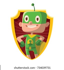 Vector frame in the form of a yellow-red shield with cartoon image of a funny little boy in a green superhero costume with a yellow cloak standing and smiling on a white background. Halloween. 