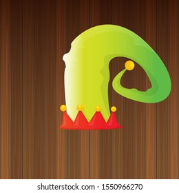 vector funky red and green stripped cartoon christmas elf hat isolated on wooden background. vector kids colorful elf hat icon or label. Christmas decorative design element for banner, flyer or poster