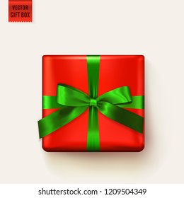Vector gift box tied with ribbon. Realistic isolated element for Christmas design, gift voucher, birthday greeting card, sale banner or other decoration. Red square giftbox with green bow. Top view.