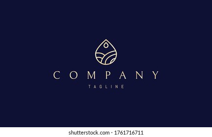 Logo de oro vectorial en el que una imagen abstracta de una gota con un paisaje montañoso dentro.