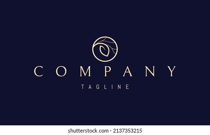 Vector golden logo on which an abstract image of a large leaf in a circle with tree branches.