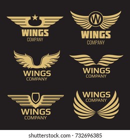 Vector golden wings logo on black backdrop. Collection of wings. Vector illustration