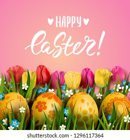 Vector greeting card with realistic golden decorated 3D eggs, grass and tulips. Handwriting inscription Happy Easter. Pink floral background. Brush lettering, modern calligraphy. 