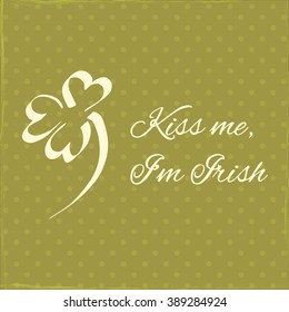 Vector greeting or invitation card for St. Patricks day with hand drawn green trefoil clover on dark polka dot background and lettering Kiss me, Im Irish. Symbol of good luck.