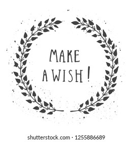 Vector hand drawn illustration of text MAKE A WISH! And floral round frame with grunge ink texture on white background. Monochrome.