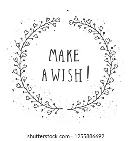 Vector hand drawn illustration of text MAKE A WISH! And floral round frame with grunge ink texture on white background. Monochrome.