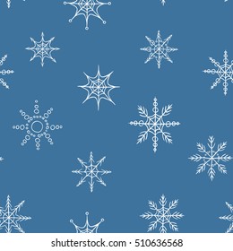 Vector hand drawn seamless pattern. White snowflakes on blue background