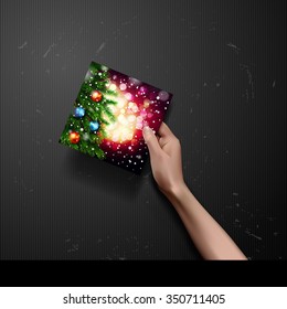 vector hand holding Christmas Greeting Card on black