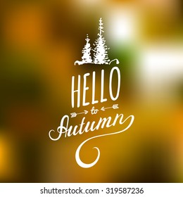 Vector hand lettering inspirational typography poster Hello autumn with spruces silhouettes on blurred background.