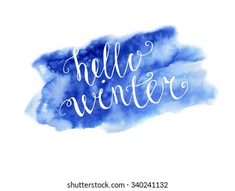 Vector hand written inscription Hello winter. Bright blue hand drawn watercolor texture and white hand written words. Calligraphic phrase.