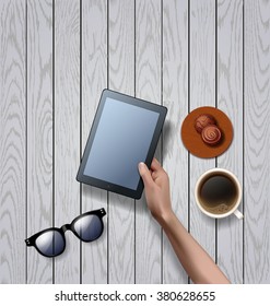 Vector hands holding empty black tablet computer with cup of black coffee and sunglasses, chocolate candy. workspace on white wooden background