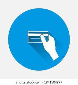 La mano del icono del vector sostiene un icono de tarjeta de crédito sobre fondo azul. Imagen plana con sombra larga.