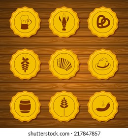 Vector icons of gold beer caps with symbols attributes Oktoberfest in retro style on dark wooden background