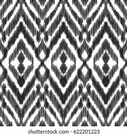 Vector illustration of the black and white colored ikat ornamental seamless pattern. Chevron design. Scribble textured effect.